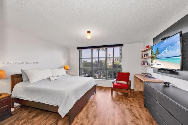 bedroom with light wood-style flooring and a textured ceiling