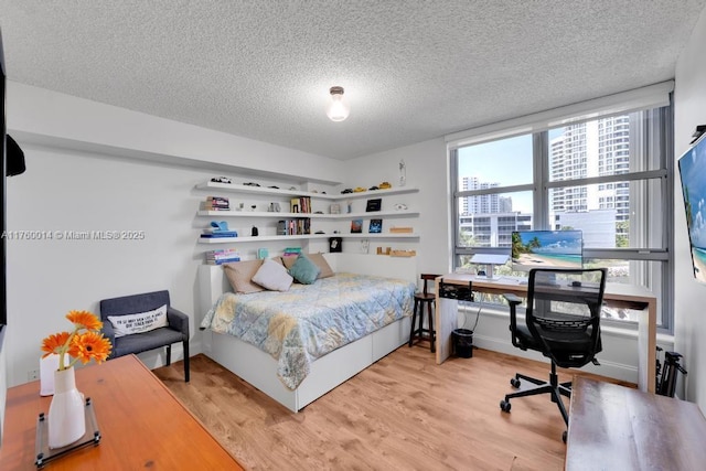 bedroom featuring a textured ceiling and wood finished floors