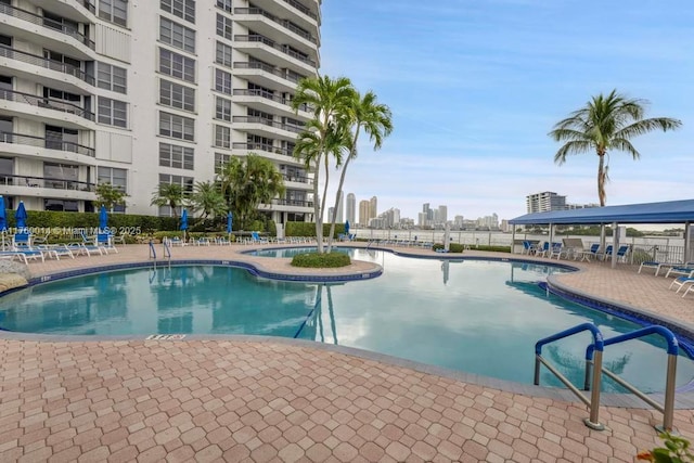 pool with a view of city, a patio, and fence