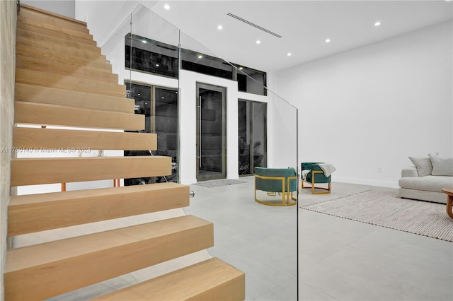 interior space with visible vents, recessed lighting, baseboards, and a towering ceiling