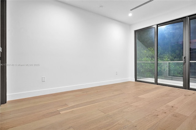 spare room featuring recessed lighting, baseboards, and light wood finished floors