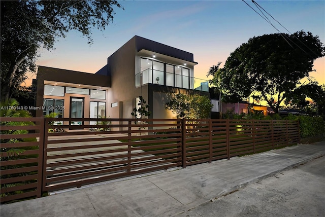contemporary house with a fenced front yard and stucco siding