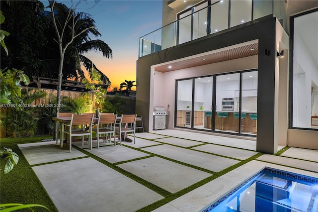 view of patio with outdoor dining space, an outdoor pool, and area for grilling