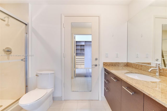 full bathroom with vanity, a shower stall, toilet, and tile patterned flooring