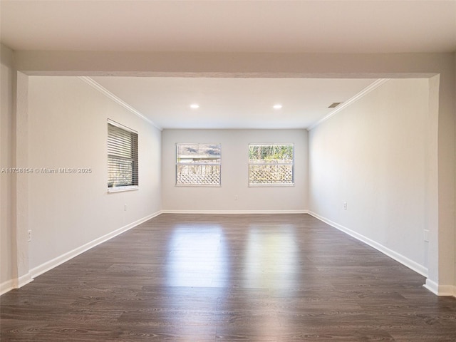 spare room featuring dark wood-style floors, baseboards, and ornamental molding