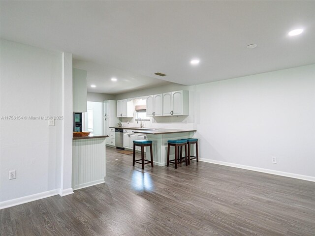 1735 18th St, Vero Beach, FL 32960 - kitchen with stainless steel dishwasher, dark wood-style floors, white cabinetry, baseboards, and recessed lighting