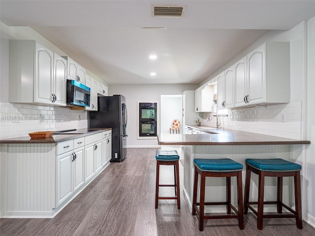 1735 18th St, Vero Beach, FL 32960 - kitchen featuring appliances with stainless steel finishes, a sink, dark wood finished floors, a breakfast bar area, and tasteful backsplash