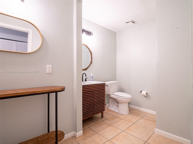 bathroom with tile patterned flooring, toilet, and baseboards