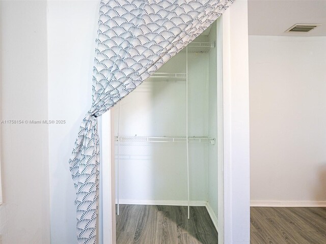 1735 18th St, Vero Beach, FL 32960 - bathroom with wood finished floors, a walk in closet, and baseboards