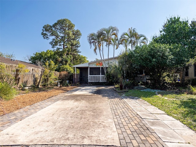 view of front facade with concrete driveway and fence