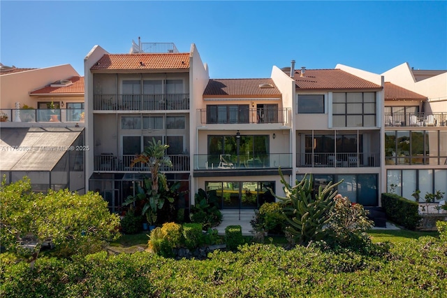 rear view of property featuring stucco siding and a tiled roof