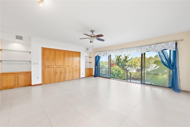 spare room with baseboards, visible vents, and ceiling fan