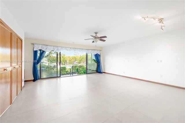 spare room featuring a ceiling fan and baseboards