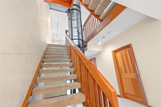 stairway with a high ceiling and baseboards