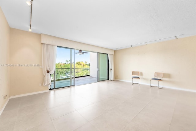 unfurnished room featuring ceiling fan, rail lighting, a textured ceiling, and baseboards