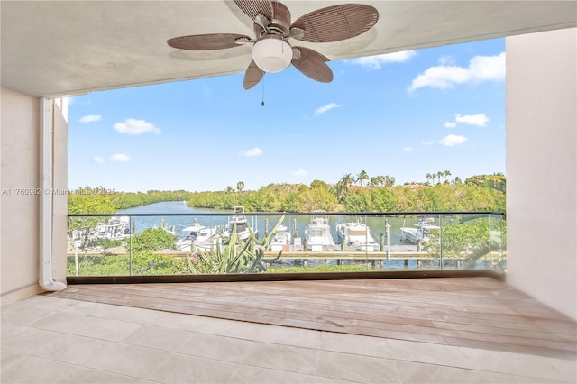 balcony featuring a water view and ceiling fan