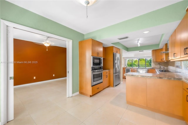 kitchen featuring visible vents, baseboards, light tile patterned floors, decorative backsplash, and stainless steel appliances