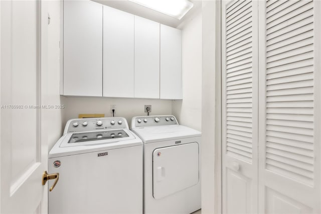 laundry room featuring separate washer and dryer and cabinet space