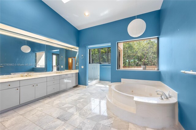 bathroom with a jetted tub, baseboards, double vanity, a stall shower, and marble finish floor