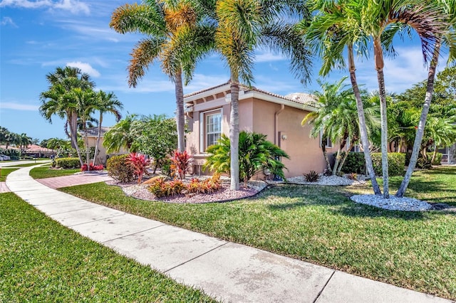 view of property exterior featuring stucco siding, a tile roof, and a yard