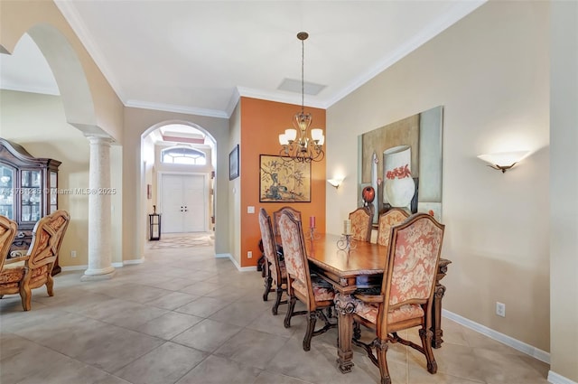 dining area featuring arched walkways, crown molding, baseboards, and decorative columns