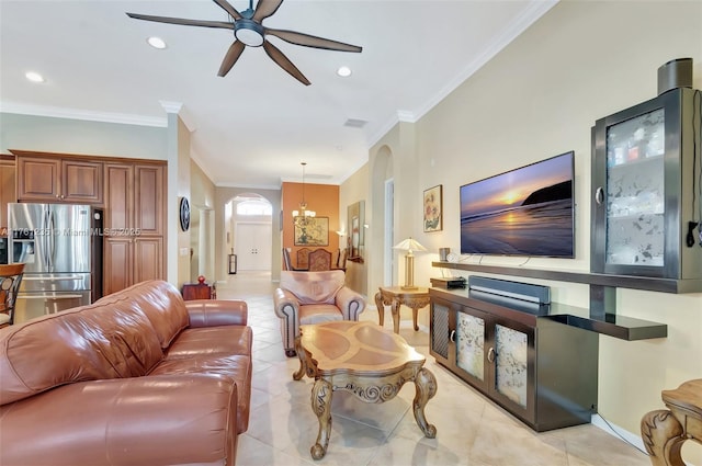 living area with ornamental molding, ceiling fan with notable chandelier, recessed lighting, arched walkways, and light tile patterned flooring