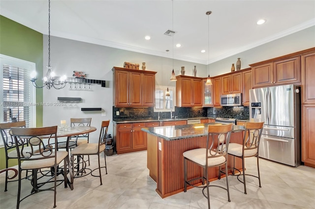 kitchen featuring decorative backsplash, brown cabinets, appliances with stainless steel finishes, and a center island