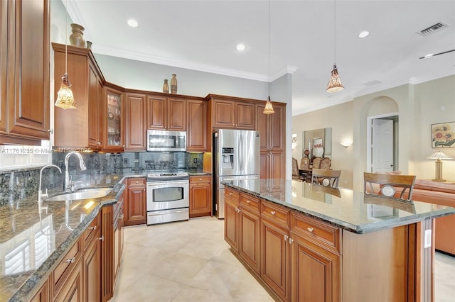 kitchen with a sink, visible vents, brown cabinets, and stainless steel appliances