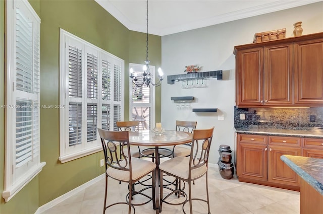 dining area with light tile patterned flooring, a notable chandelier, baseboards, and ornamental molding