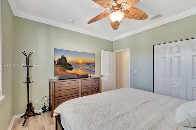 bedroom featuring visible vents, ceiling fan, ornamental molding, wood finished floors, and a closet