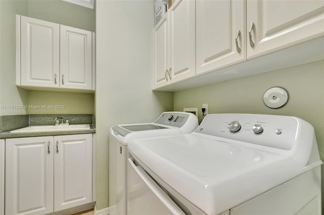 laundry room featuring cabinet space, washing machine and dryer, and a sink