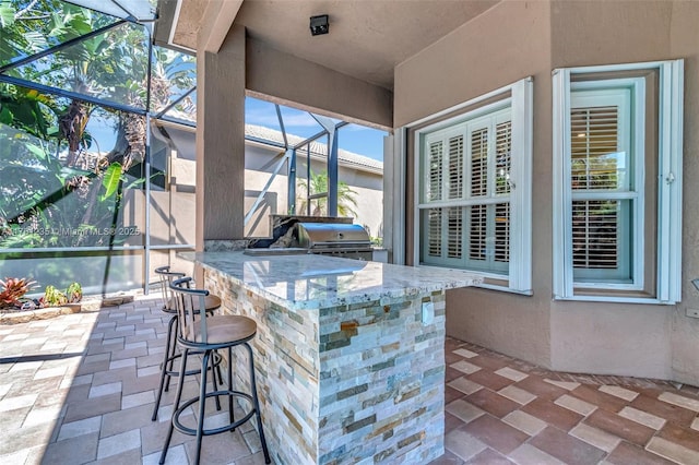 view of patio / terrace featuring grilling area, outdoor wet bar, area for grilling, and glass enclosure