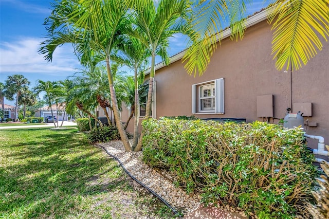 view of home's exterior featuring stucco siding and a lawn