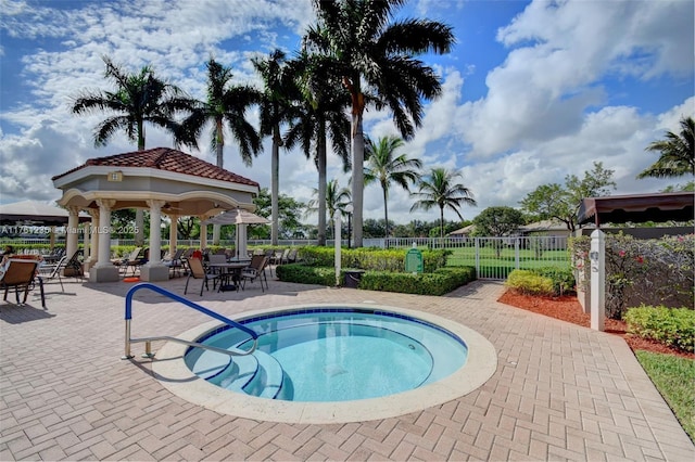 view of pool featuring a gazebo, a patio area, a hot tub, and fence