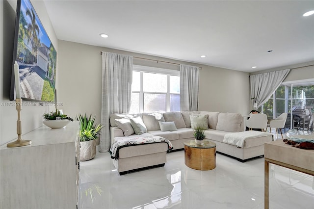 living room with a wealth of natural light, marble finish floor, and recessed lighting