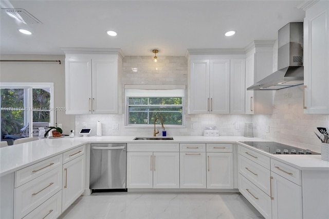 kitchen with visible vents, black electric stovetop, stainless steel dishwasher, wall chimney exhaust hood, and a sink