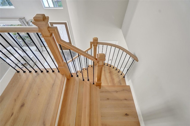 stairway with baseboards and wood finished floors