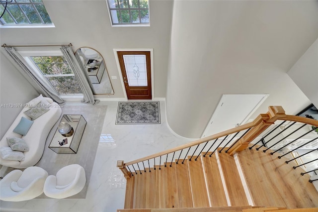 entrance foyer with plenty of natural light, a high ceiling, and stairs