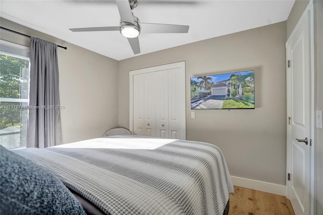 bedroom with a ceiling fan, baseboards, a closet, and light wood finished floors