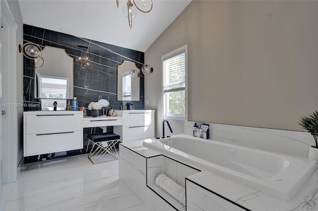 full bath featuring a bath, marble finish floor, vanity, and vaulted ceiling