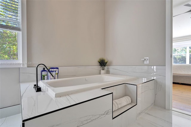 bathroom featuring a tub and marble finish floor