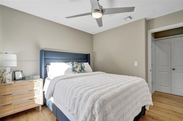 bedroom featuring visible vents, a ceiling fan, and wood finished floors