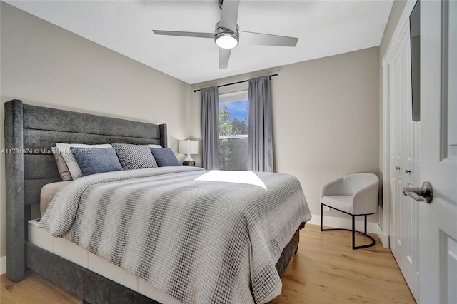 bedroom featuring a closet, light wood-style flooring, a ceiling fan, and baseboards