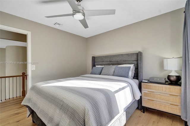 bedroom with light wood-style flooring, a ceiling fan, and visible vents