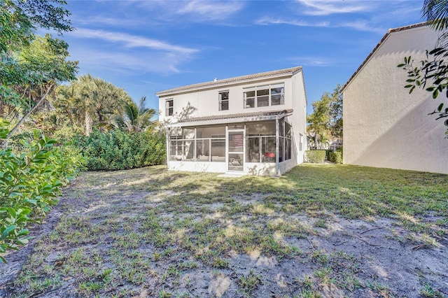 back of house with a yard and a sunroom