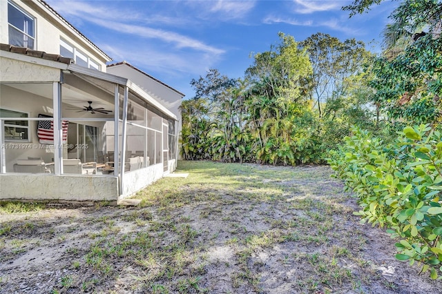 view of yard with a sunroom and ceiling fan