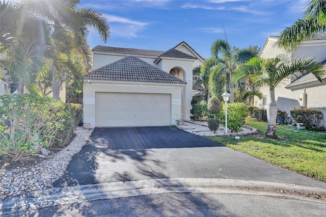 view of front of house with aphalt driveway, an attached garage, a tile roof, and stucco siding