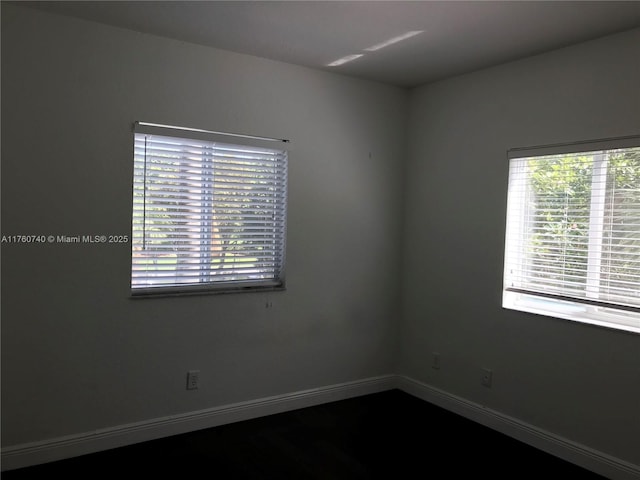 unfurnished room with baseboards
