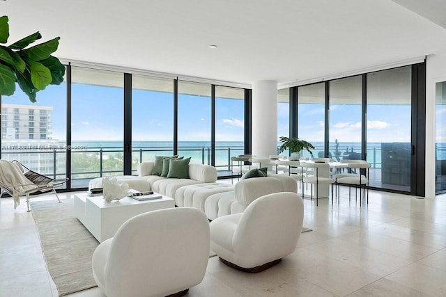 living area featuring floor to ceiling windows, plenty of natural light, and a water view