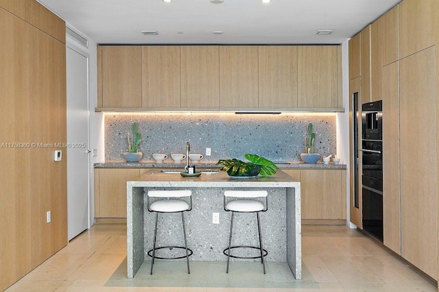 kitchen with light brown cabinetry and modern cabinets